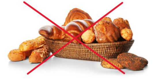 Assortment of fresh pastries in wicker bowl isolated on white